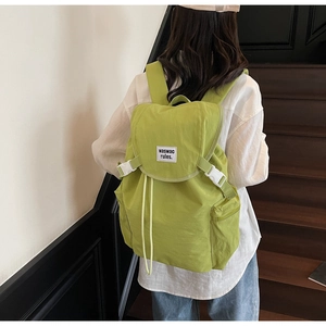 Vue détaillée du sac à dos en nylon vert avocat avec boucles blanches et logo frontal