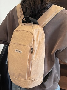 Minimalist light khaki nylon backpack for women shown from back view on a model
