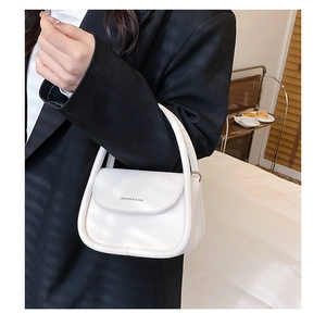 Macro shot of a white faux leather handbag featuring Fashion & Bags logo lettering