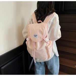 Détail du sac à dos rose pâle avec fermeture à rabat et poche latérale pratique