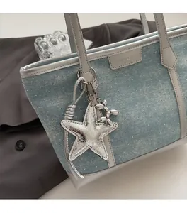 Detail of light blue polka dot tote bag with silver star and balloon dog pendants