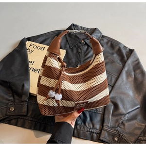 Close-up of striped woven hobo bag with leather handle and decorative bead details
