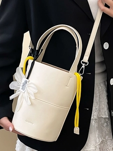 Cream floral bucket bag for women featuring detachable flower charm and shoulder strap