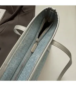 Detail of silver zipper and glitter fabric on the stylish blue tote bag with metallic accents