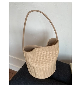 Close-up of cream woven texture and fine V-shaped craftsmanship on this shoulder tote bag