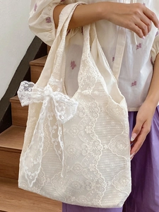 Lace tote bag with flower embroidery and large bow detail shown in lifestyle setting