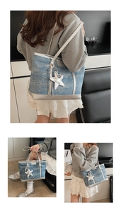Detail of blue denim tote bag featuring silver metallic trim and a star charm