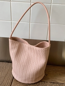 Pink woven bucket bag with V-shaped pattern and adjustable shoulder strap for women