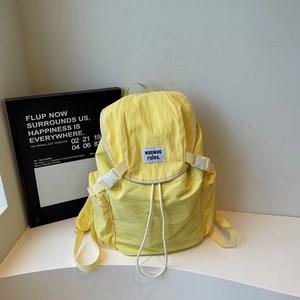 Détail d'un sac à dos en nylon jaune avec fermeture à cordon et boucle blanche robuste