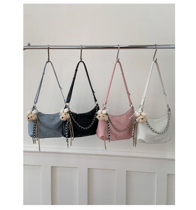 Detailed row of half-moon shoulder bags in four colors with chain and bear charms
