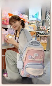Close-up of pink and blue school backpack with cute bunny pins and functional compartments