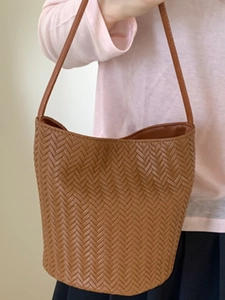 Brown woven leather bucket bag with Intrecciato pattern and slender shoulder strap