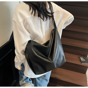 Detailed view of the soft black leather texture on this minimalist shoulder tote bag