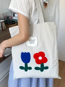 Beige canvas tote bag with tulip embroidery and fearless phrase in casual style