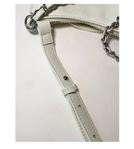 Detail of creamy white leather tote bag showing silver metal hardware and adjustable strap