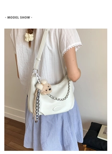 White hobo shoulder bag with silver chain, plush bear pendant and checkered ribbon detail