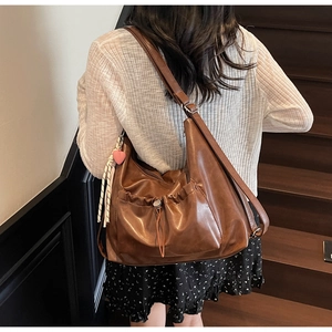 Detail shot of a brown vintage tote bag with drawstring pocket and heart charm