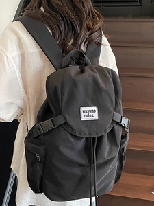 Sac à dos tendance 2025 en nylon noir grande capacité avec rabat porté par un modèle