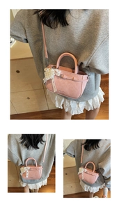 Close-up of pink embossed leather tote bag with pearl bow charm and logo detail