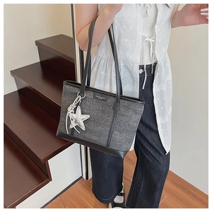 Detail of grey snowflake texture fabric tote bag with leather straps and astronaut charm