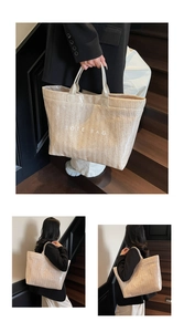 Close-up detail of beige woven tote bag texture with white TOTE BAG lettering print