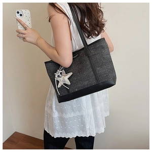 Detail of grey canvas tote bag with star pattern, PU leather base and star charm