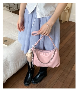 Detailed shot of pink faux leather tote bag with silver chain and cute bear charm