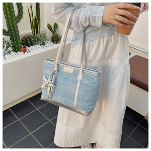 Light blue denim tote bag detail featuring silver metallic trim and star charm