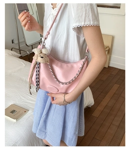Detail of pink leather tote with plush bear charm and silver chain strap