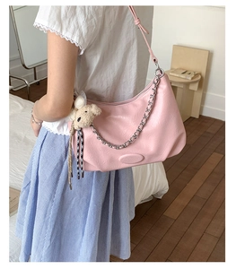 Pink PU leather crescent shoulder bag with metal chain detail and plush bear charm