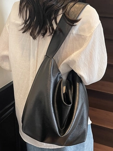 Minimalist black soft leather tote bag for women shown from a stylish back view on stairs