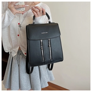 Détail du sac à dos en similicuir noir montrant la vue latérale et les zips métalliques