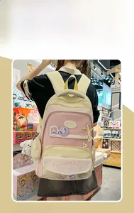 Detailed view of a pink school backpack with cute cartoon patches and a white puppy pendant