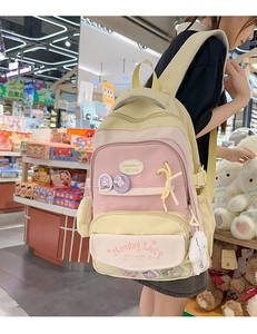 Detail view of colorful multi-pocket school backpack with cute rabbit pendant and badges