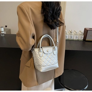 Detail of silver quilted handbag featuring metallic finish and elegant metal handle