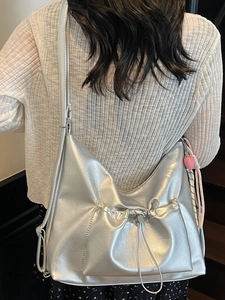 Silver metallic pleated tote bag with drawstring pocket and heart pendant scarf detail