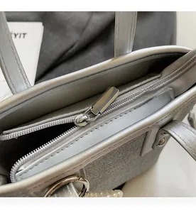 Detailansicht des glatten Reißverschlusses und der Perlenverzierung an der Glitzertasche
