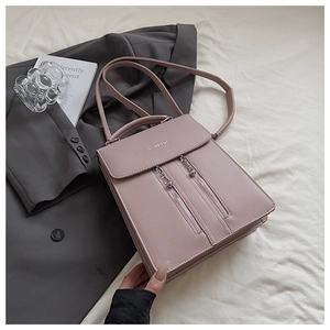 Détail du sac à dos en cuir mat rose poudré avec rabat magnétique et deux fermetures éclair