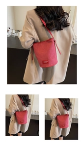 Detail der roten Wildleder-Beuteltasche mit Marken-Lederpatch und glatten Metallteilen