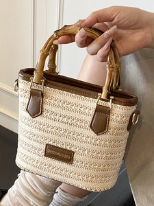 Fashionable woven straw bucket bag with bamboo handle and leather trim details
