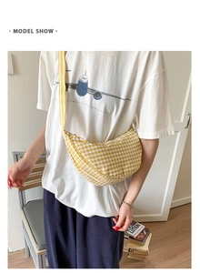 Chic yellow checkered dumpling bag with wide shoulder strap styled on a casual model outfit