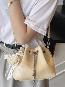Schicke beige glänzende Beuteltasche mit Perlenherz und Schleife für Damen