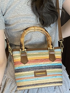 Colorful woven straw bucket bag with natural bamboo handles and adjustable leather strap