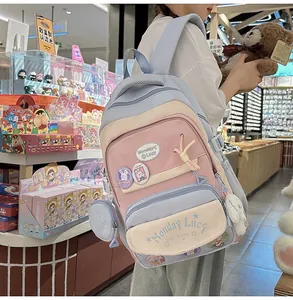 Detail view of multi-compartment student backpack with cute badges and plush charms