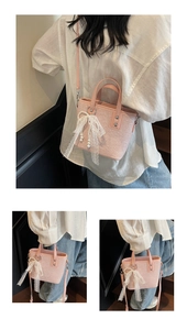 Detail der rosa Mode-Eimertasche mit Spitzenschleife und Perlenanhänger Textur