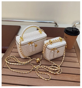 Close-up of ostrich texture leather bags with gold handles and floral zipper charms