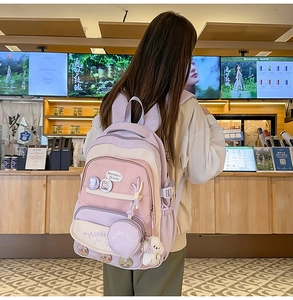 Detail of pink and lavender school backpack with cute puppy pendant and coin purse