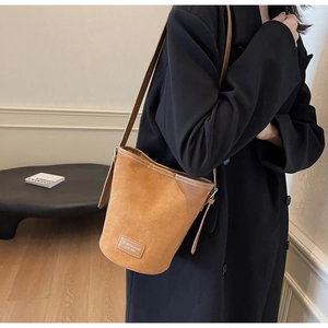 Braune gefrostete Beuteltasche mit Lederetikett und schwarzem Blazer für die Arbeit