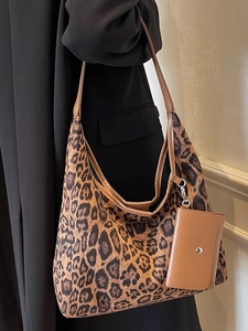 Large capacity leopard print tote bag with brown pouch worn by a model in a minimal setting