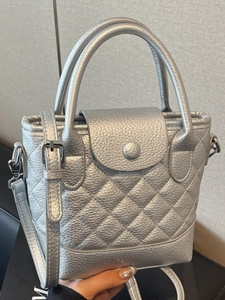 Silver quilted bucket bag with double handles and adjustable strap in metallic finish